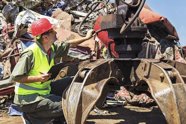 Arbeiter inspizieren Kran auf Schrottplatz. — Stockfoto