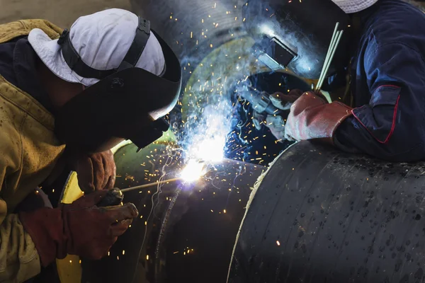 Two workers together welding big tube — Stock Photo, Image