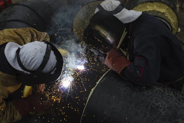 Two workers together welding big tube for city heating. — Stock Photo, Image