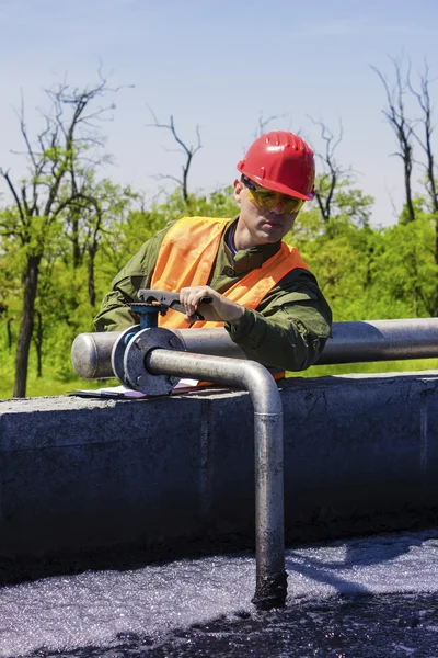 Worker monitor filtering industrial water — Stock Photo, Image