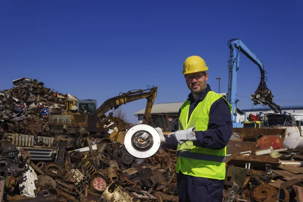 Inspector hold old car rotor on junkyard — Stock Photo, Image