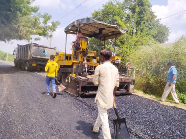 Vadodara, Gujarat 24 Haziran 2021 Karayolu ve makineyle çalışan insanlar