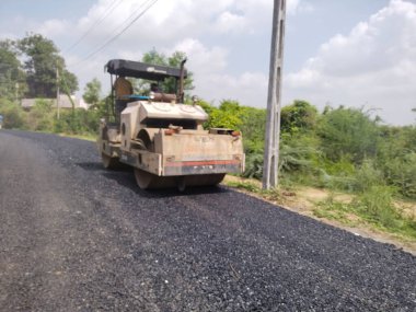 Vadodara, Gujarat 24 Haziran 2021 Karayolu ve makineyle çalışan insanlar