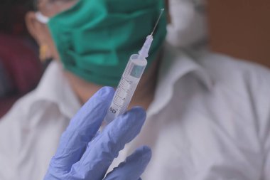 Kadın doktorların elinde şırıngayla fotoğraflarını çek.