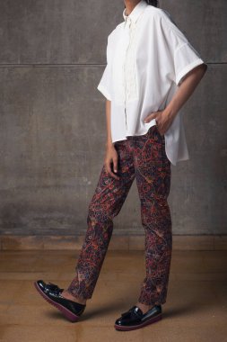 Genç bir kadın elleri cebinde duruyor.