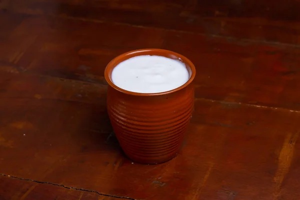 Koyu ahşap arka planda geleneksel kaymak tenceresinde taze kaymak.