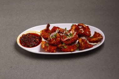 Gri arkaplanda tatlı soslu kızarmış karides köftesi.