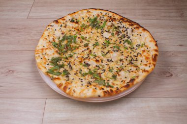 Tandır kulcha ya da naan olarak da bilinen Hint özel düz ekmeği, beyaz seramik çeyrek tabakta servis edilir.
