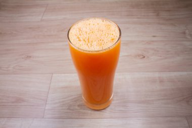 Cam sürahide portakal suyu ve ahşap arka planda portakal suyu. Yatay oryantasyon. Boşluğu kopyala.