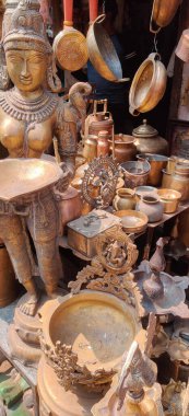 Kırmızı arkaplan üzerine altın ve bronz harflerle yazılmış Budist figürler ve maskeler.