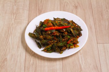 Hint usulü Masala Sabji OR Sabzi kızartılmış Bhindi or Bamya lakaplı, ahşap arka planda bir kasede servis ediliyor. seçici odak
