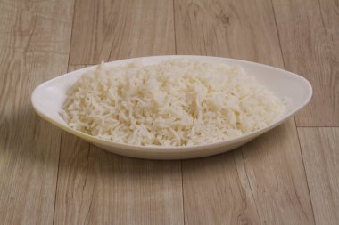 Ahşap zemin üzerinde kase içinde sade beyaz basmati pilavı pişirdim.