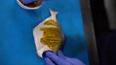 Erkek şef marinette için pomfret balığı hazırlıyor. Mutfakta balık pişiriyorum. Yemekleri hazırlamak için şef tarafından hazırlanan malzemeler. Restoranın mutfağında yemek pişirmek. Doğal bulanıklık ve sallanan kamera.