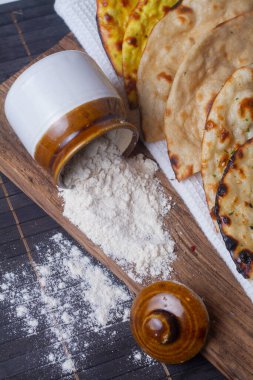 Ahşap zemin üzerine un dökülmüş kavanoz.