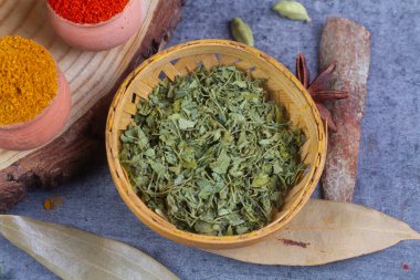 Bambu kasesinde ahşap arka planda kasoori metisi.