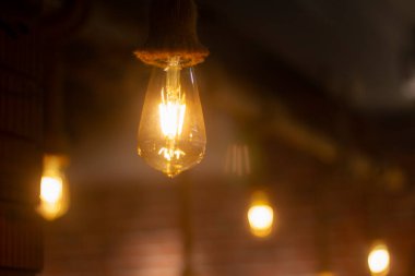 Antika ampul, arka planda bulanıklık olan lamba dekorasyon ve arka plan fotoğrafı için Hindistan 'daki kahve dükkanında asılı. seçici odak.