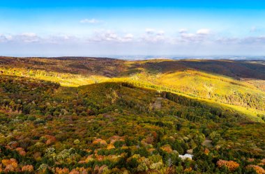 Açık mavi gökyüzü ile çok renkli sonbahar tepelerinin manzarası.