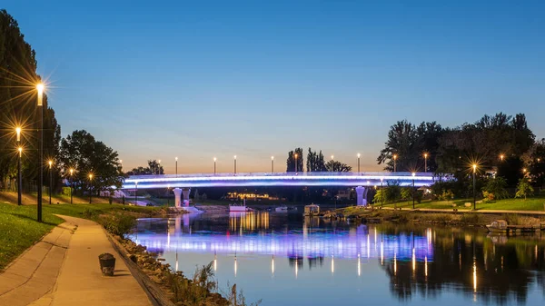 ハンガリーのGyorのダウンタウンにあるカラフルな夜の街並み 橋と川の上の夕日 — ストック写真