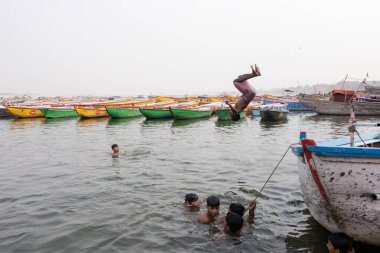 Varanasi Borsası 'nda Ganga Nehri' ne atlayan Hintli çocuklar.