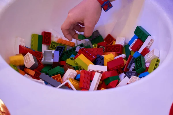 Çocukların ellerinin çeşitli şekillerde birbirine kenetlenmiş plastik tuğlalarla oynamalarını kapat