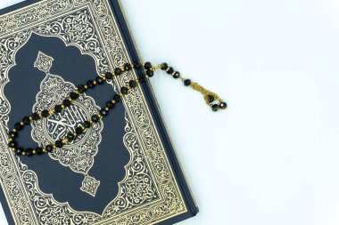 Kuran ve siyah renkli tespih beyaz arka planda