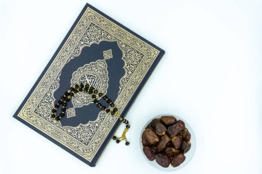 Kuran ve siyah dua boncukları ve plastik kaplarda beyaz arkaplan üzerine tarihler