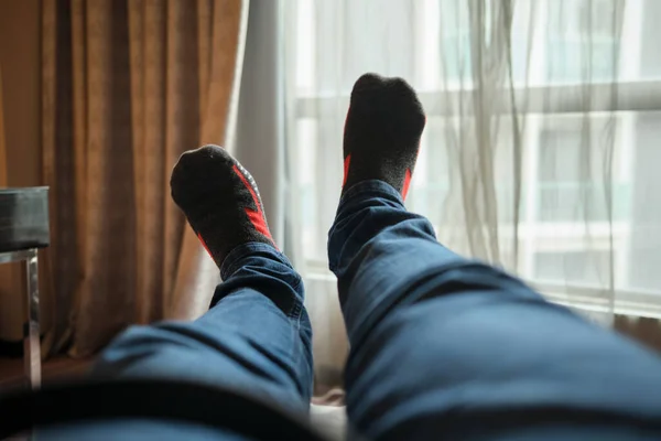 Otel odasında rahatlayan bir adamın seçici odak noktası.