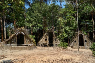 Tropik ormanın ortasında üç ahşap kulübe.