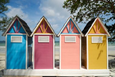 Sahildeki küçük renkli soyunma odaları gökyüzüne karşı.