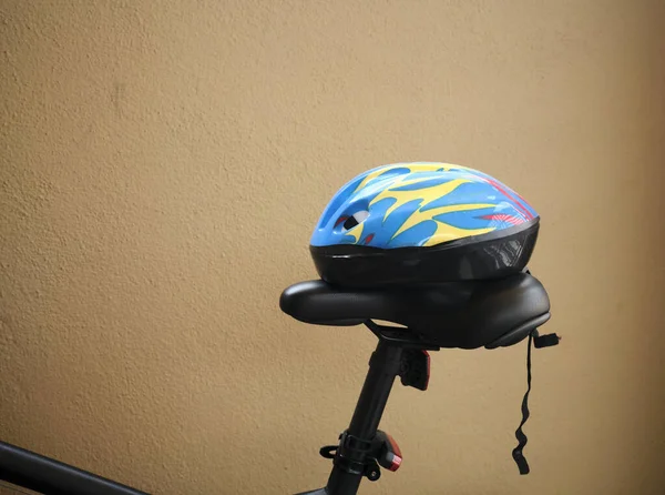黒い自転車の座席の上に子供のための青い色の自転車ヘルメット — ストック写真