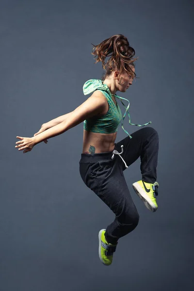 Esmer kız sokak dansı yapıyor.