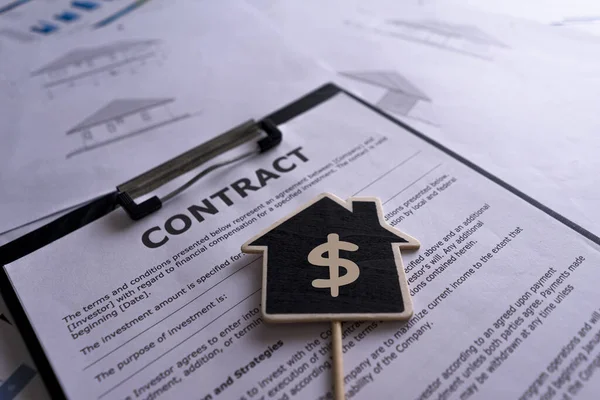 House sale sign with the home purchase contract, calculator, house key, price house paper, home design document.
