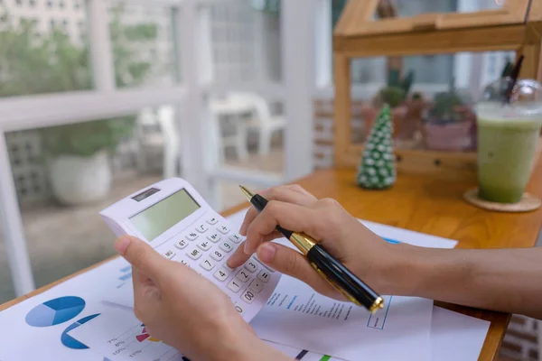 Hesap makinesi, iş belgesi, iş verileri, muhasebe belgesi, akıllı modern ofis veya kahve dükkanında yatırım istatistiksel verileri ile çalışan iş kadını veya muhasebeci.