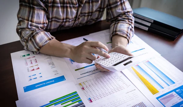 Bir muhasebeci finansal hesapları, gelir ve zarar istatistiklerini, şirket gelirlerini hesaplamak için hesap makinesi kullanıyor. Muhasebe ve iş konsepti.