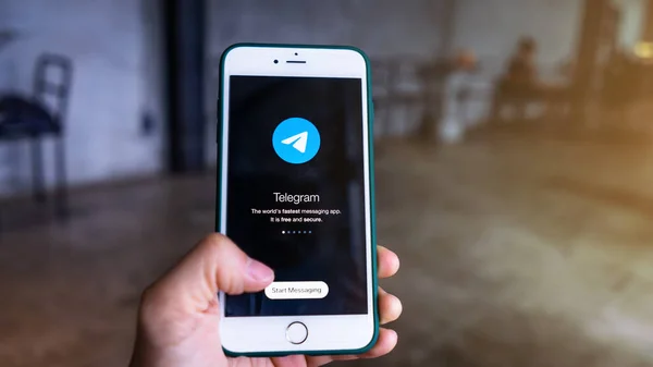 CHIANG MAI, THAILAND, 1 Ağustos 2021: Kadın el ele tutuşan iPhone ve Telegram Uygulama simgesi kullanıyor. Telgraf piyasadaki en hızlı mesajlaşma uygulaması..