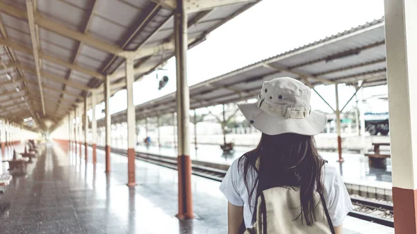 Banner Vintage tarzı. Sırt çantalı genç bayan turistler trenin tren istasyonuna gitmesini bekliyorlar. Seyahat ve tatil kavramı