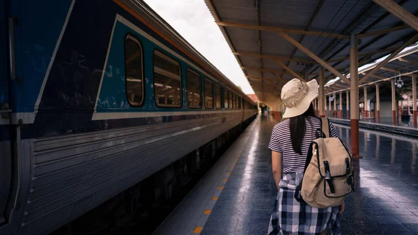 Aktif ve seyahat yaşam tarzı konsepti. Genç bayan turist tren istasyonunda sırt çantasıyla yürüyor..