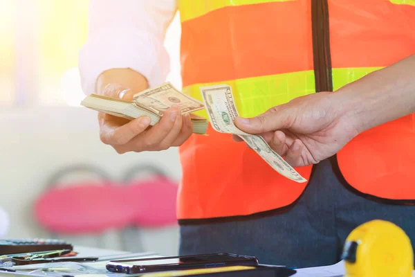 Engineers and Foreman are calculating workers\' expenses and overtime to pay workers compensation and overtime each month. Foreman holds cash in hand to pay workers as compensation