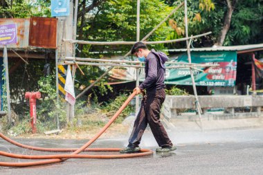 Chiang Mai / Tayland-Nisan 14.2020: Belediye yetkilileri kazadan sonra toprak ve yağ lekelerini temizlemek için yollar temizliyor, yol yüzeyini petrol temizleyicisiyle dolduruyor ve kazara meydana gelen kazaları önlüyor