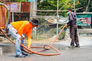 Chiang Mai / Tayland-Nisan 14.2020: Belediye yetkilileri kazadan sonra toprak ve yağ lekelerini temizlemek için yollar temizliyor, yol yüzeyini petrol temizleyicisiyle dolduruyor ve kazara meydana gelen kazaları önlüyor