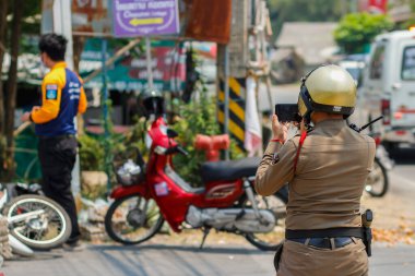 Chiang Mai / Tayland-April14.2020: Polis memurları trafik kazalarının kanıtlarını kaydediyor ve trafik kazalarının tekrarlanmaması için arabalara kolaylık sağlıyor. Polis kanıtları kaydediyor..