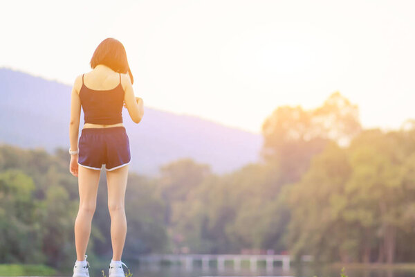 Blurred image, a young woman wears sportswear and running shoes to get ready to warm up before the training run to get ready for the next race. Training ideas to get ready for running