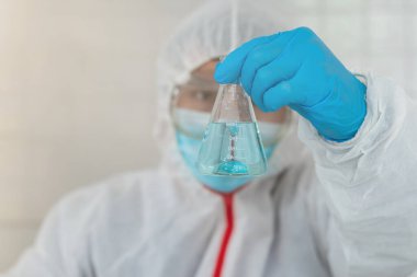 Ekip doktorları COVID-19 koronavirüsünü incelemek ve salgını durdurmak için koronavirüs aşısını araştırmak için koronavirüs koruyucu giysi ve lastik eldiven giyerler..