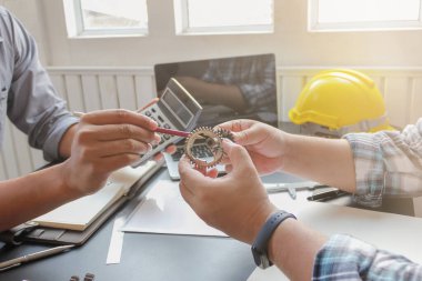 Mühendisler ve tasarımcılar, makinenin güvenli çalışması ve müşterilerin istediği gibi tasarlanması ve hesaplanması için makine yapısı hakkında tartışmak ve danışmak üzere bir araya geldiler..