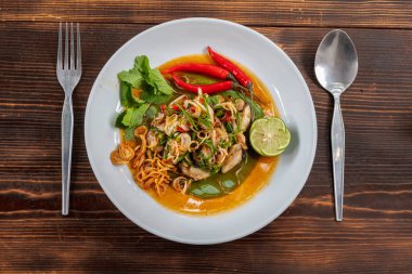 Taze istiridyeler beyaz bir tabakta servis edilir ve baharatlı Tayland usulü sos ile kaplanır, 