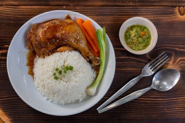 Kızarmış tavuk butları ve but çubukları yasemin pilavı ve beyaz tabakta taze sebzelerle servis edilir. Tatlı ve lezzetli sosta pişirilmiş tavuk butları sıcak pilavla servis edilir..