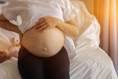 The expectant mother put her hands on her belly lovingly because she felt the force of the baby in the womb, and she prayed to God with her faith and power to deliver the baby and she is safe
