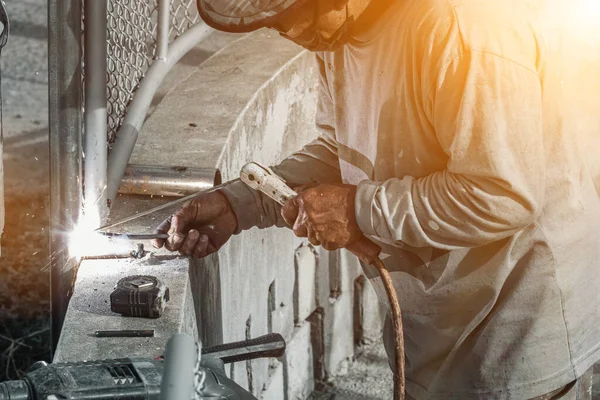 一个焊工正在焊接钢以制造房屋的安全栅栏 用专业焊接技巧保护客户安全的施工焊接钢或栅栏的概念 — 图库照片
