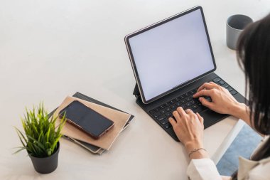 Bir iş kadını internet üzerinden iletişim kurmak ve işi kontrol etmek için dizüstü bilgisayar kullanıyor çünkü internetten istediği yerden sipariş verip kontrol edebilen bir iş kuruyor.