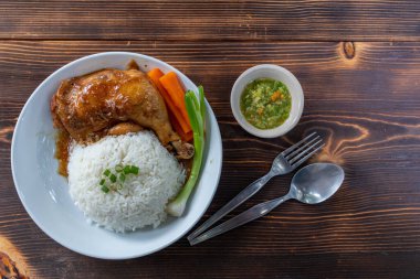 Kızarmış tavuk butları ve but çubukları yasemin pilavı ve beyaz tabakta taze sebzelerle servis edilir. Tatlı ve lezzetli sosta pişirilmiş tavuk butları sıcak pilavla servis edilir..